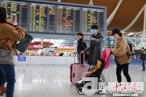 旅客帶著孩子前往辦票柜臺辦理登機(jī)手續(xù)?！∫罅⑶?攝