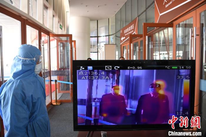 圖為游客步行通過紅外線測(cè)溫通道?！钇G敏 攝