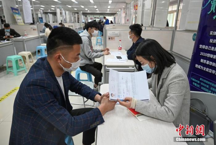 4月14日，招聘者在查看求職者簡歷。<a target='_blank'  data-cke-saved- >中新社</a>記者 王剛 攝