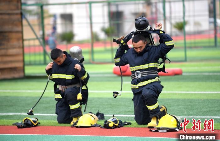 新消防員進(jìn)行穿戴空呼器展示?！⒅铱?攝