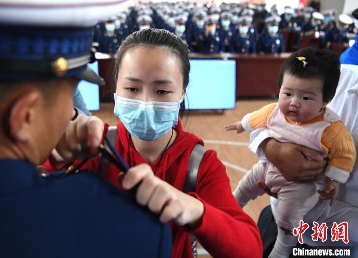 新消防員楊振的妻子彭莉與女兒現(xiàn)場(chǎng)見證丈夫加入“火焰藍(lán)”的神圣時(shí)刻?！⒅铱?攝