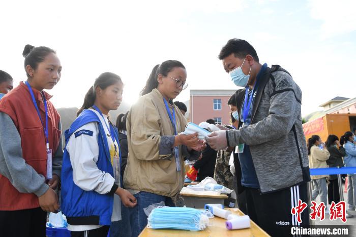 7月7日，考生在拉薩三高考點(diǎn)外領(lǐng)取口罩?！『闻罾?攝