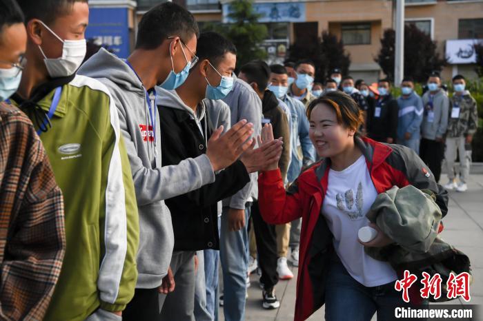 7月7日，拉薩三高考點(diǎn)外，領(lǐng)隊(duì)老師與考生擊掌鼓勁加油?！『闻罾?攝