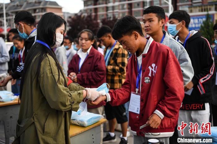 7月7日，考生在拉薩三高考點(diǎn)外測(cè)量體溫?！『闻罾?攝