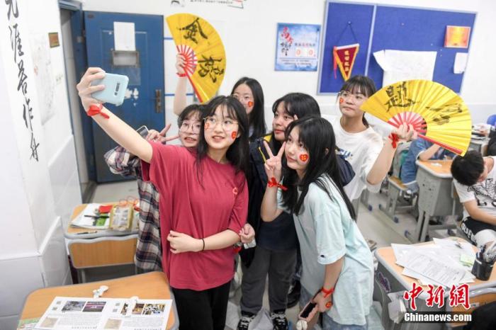 資料圖：6月6日，2021年高考前夕，湖南長(zhǎng)沙同升湖實(shí)驗(yàn)學(xué)校高三年級(jí)，考生們?cè)诮淌覂?nèi)合影。 楊華峰 攝